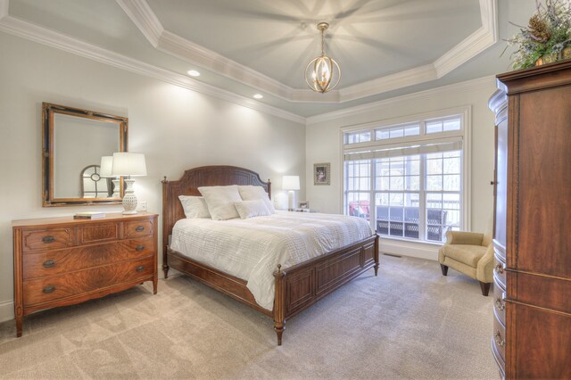 carpeted bedroom featuring an inviting chandelier, ornamental molding, and a raised ceiling