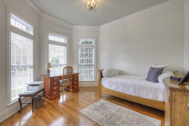 bedroom with crown molding and light hardwood / wood-style floors