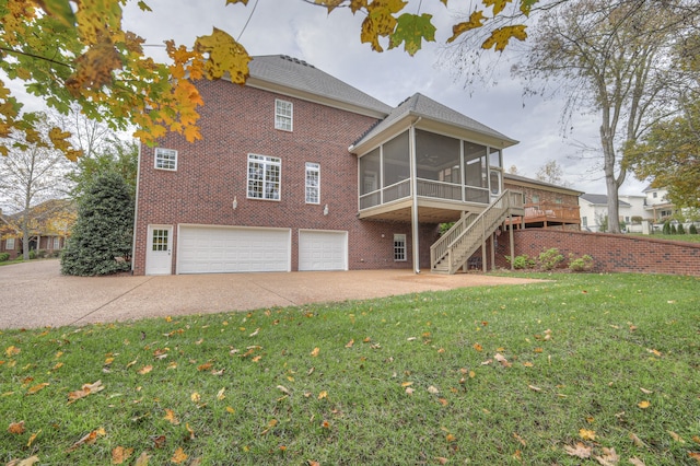 back of house with a wooden deck, a garage, a yard, and a sunroom