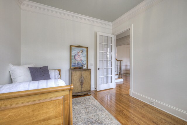 bedroom with ornamental molding and hardwood / wood-style floors