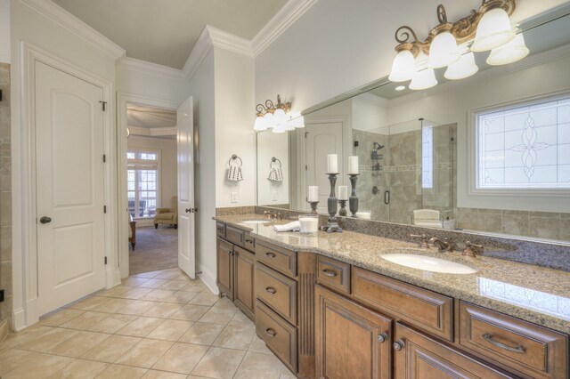 bathroom featuring ornamental molding, tile patterned flooring, a shower with door, and vanity