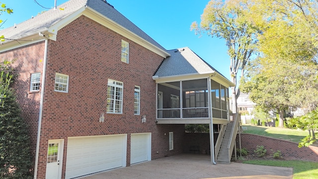 back of house featuring a garage and a sunroom