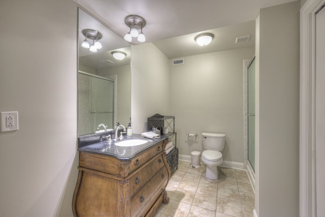 bathroom with vanity, toilet, a shower with shower door, and tile patterned flooring