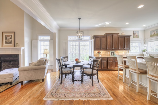 dining area featuring crown molding, plenty of natural light, and light hardwood / wood-style flooring