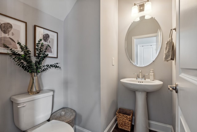 bathroom featuring sink, toilet, and vaulted ceiling