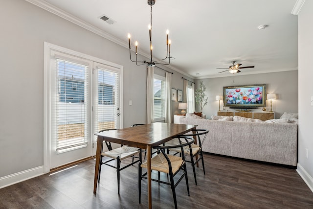 dining space featuring dark wood-type flooring, ornamental molding, and ceiling fan with notable chandelier