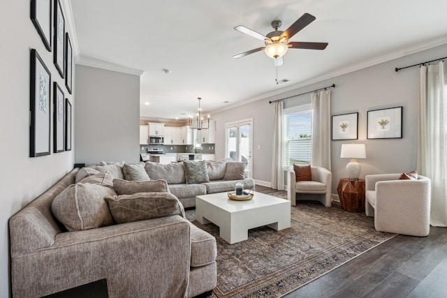 living room featuring ceiling fan with notable chandelier, dark wood-type flooring, and crown molding