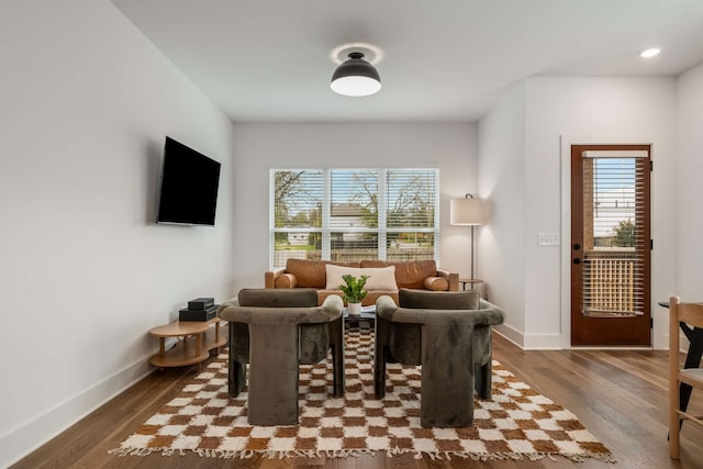 living room with plenty of natural light and dark wood-type flooring