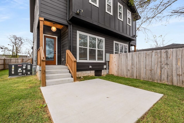 entrance to property featuring a yard and a patio