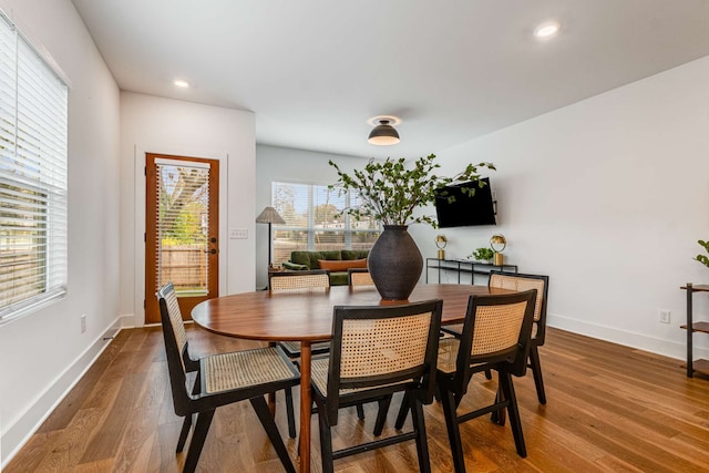 dining space with a wealth of natural light and hardwood / wood-style floors