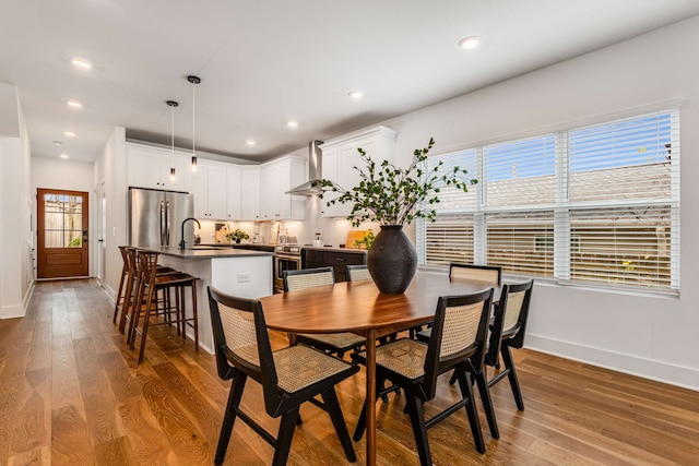 dining room featuring sink, plenty of natural light, and light hardwood / wood-style flooring