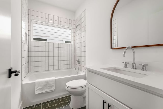 full bathroom with vanity, tiled shower / bath combo, and toilet