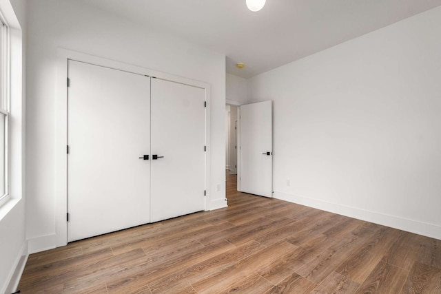 unfurnished bedroom with wood-type flooring and a closet