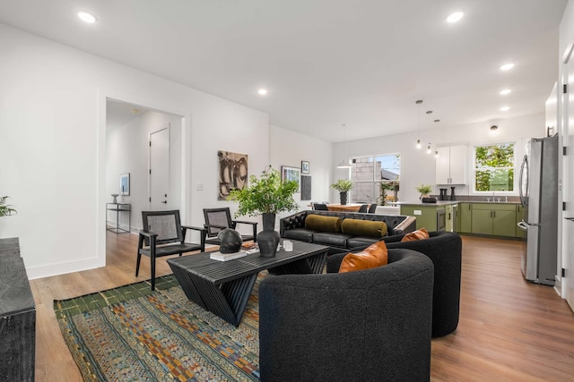 living room with sink and light hardwood / wood-style flooring