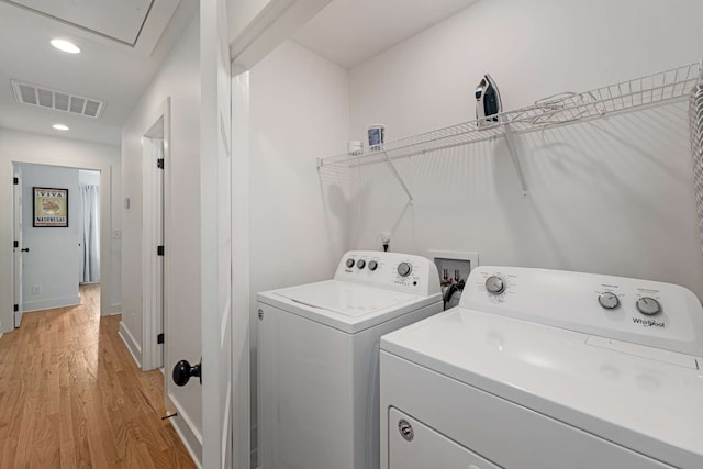 washroom featuring washer and clothes dryer and light hardwood / wood-style floors