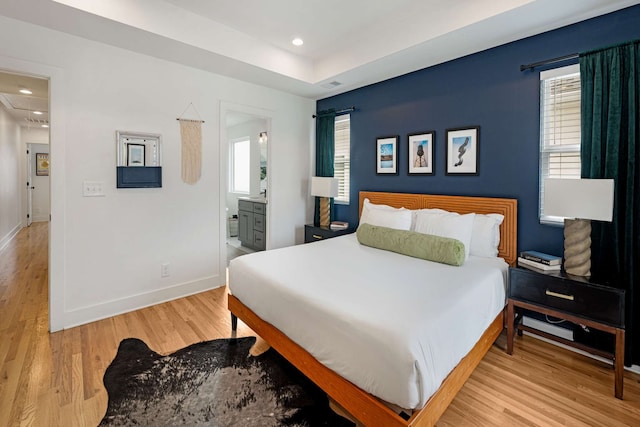 bedroom featuring light wood-type flooring and ensuite bathroom