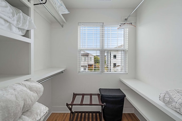 walk in closet with dark hardwood / wood-style flooring