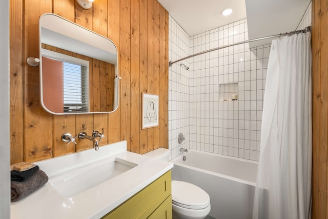 full bathroom with wooden walls, shower / tub combo with curtain, vanity, and toilet