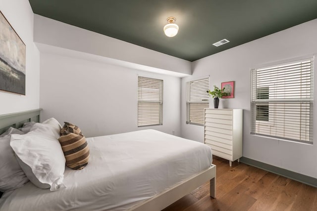 bedroom featuring dark hardwood / wood-style flooring and multiple windows