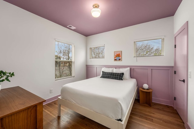 bedroom featuring hardwood / wood-style flooring and multiple windows