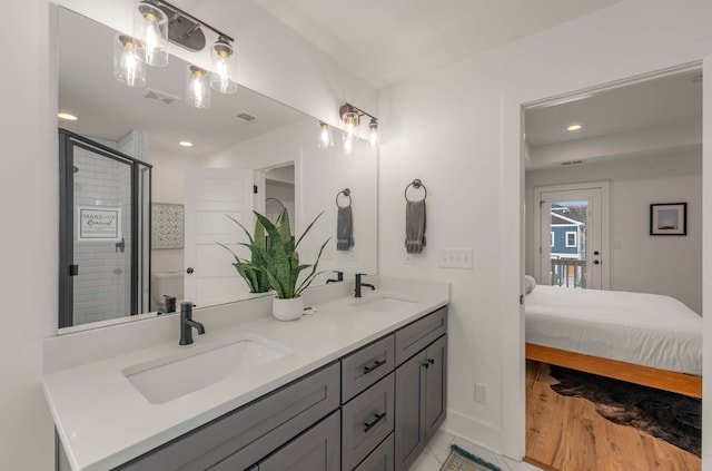 bathroom with vanity, a shower with shower door, and hardwood / wood-style flooring