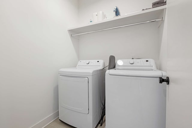 clothes washing area featuring light tile patterned floors and independent washer and dryer