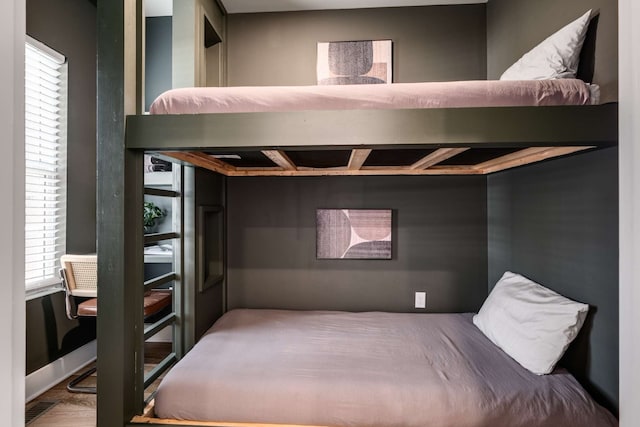 bedroom with wood-type flooring and multiple windows