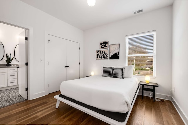 bedroom with dark hardwood / wood-style flooring and a closet