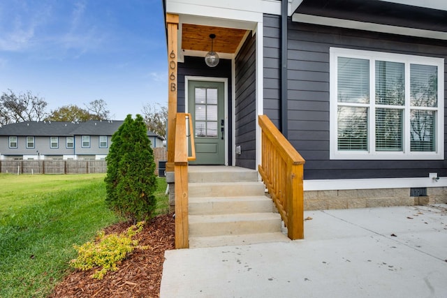 view of exterior entry with a yard