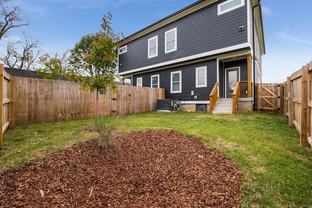 back of property with central AC unit and a lawn