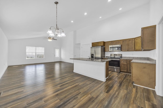 kitchen featuring appliances with stainless steel finishes, dark hardwood / wood-style flooring, high vaulted ceiling, pendant lighting, and a kitchen island with sink