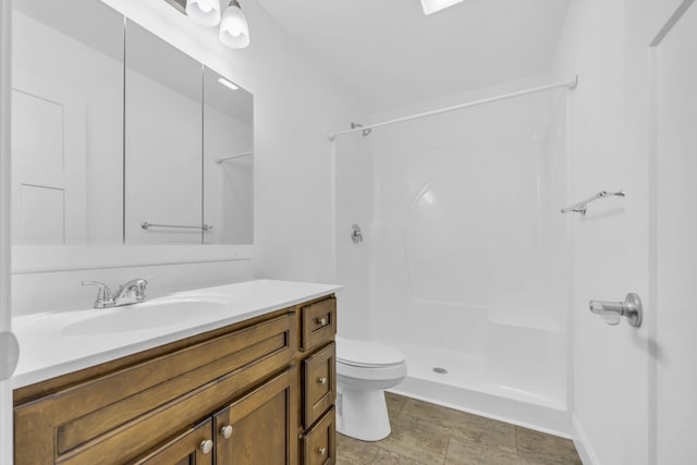 bathroom featuring vanity, toilet, and a shower