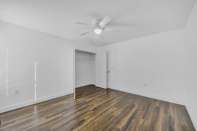 unfurnished bedroom with dark wood-type flooring, a closet, and ceiling fan