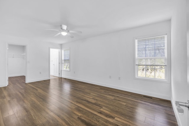 unfurnished room with ceiling fan, dark hardwood / wood-style floors, and plenty of natural light