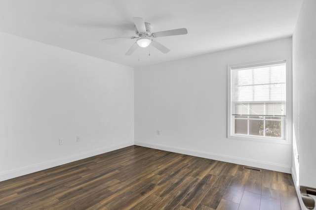 empty room with dark wood-type flooring and ceiling fan