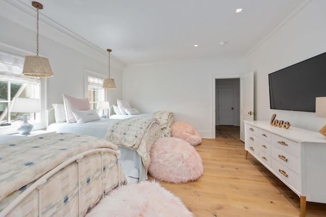 bedroom with light wood-type flooring and crown molding