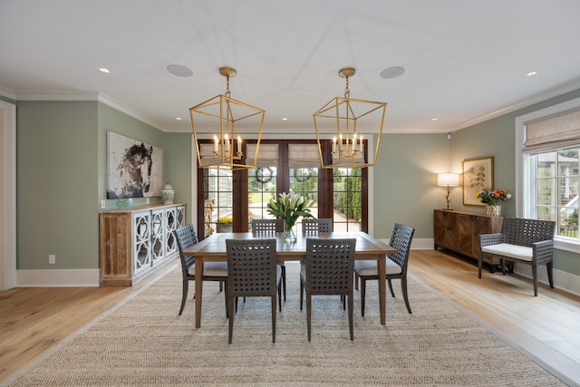 dining area featuring light hardwood / wood-style floors, a chandelier, french doors, and ornamental molding