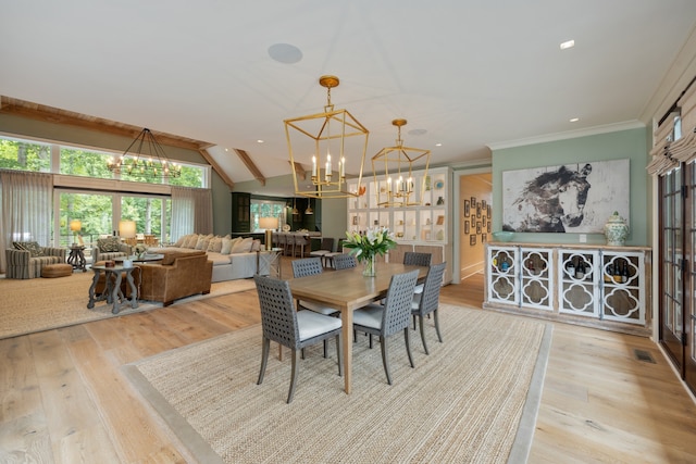 dining area with a chandelier, vaulted ceiling, light hardwood / wood-style floors, and crown molding