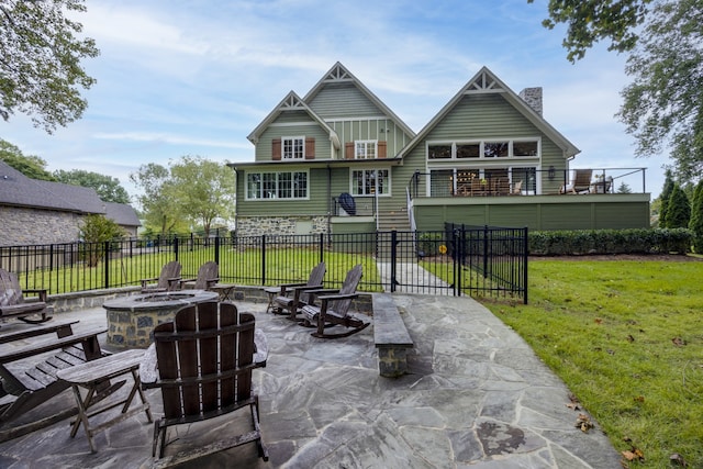 back of property with a balcony, a lawn, a fire pit, and a patio area