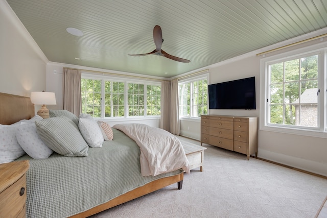 bedroom with ceiling fan, multiple windows, and ornamental molding