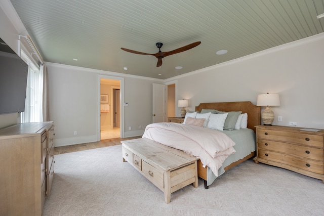 bedroom featuring ornamental molding, light hardwood / wood-style floors, ceiling fan, and ensuite bath