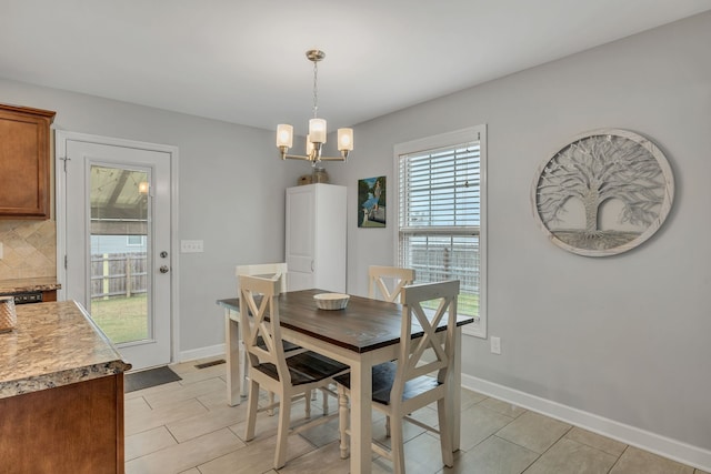 tiled dining room with a notable chandelier