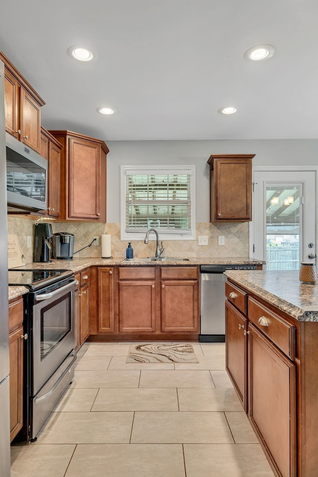 kitchen with decorative backsplash, appliances with stainless steel finishes, and sink