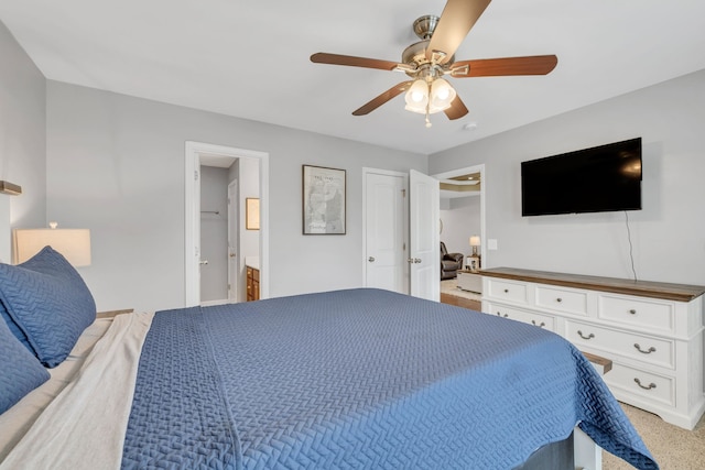 bedroom with light carpet, ceiling fan, and ensuite bathroom