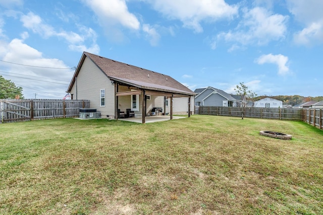 back of property featuring a fire pit, a lawn, and a patio area