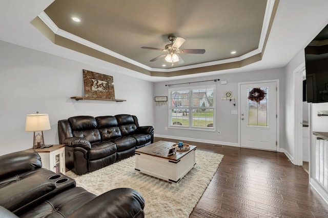 living room featuring ceiling fan, dark hardwood / wood-style floors, a raised ceiling, and crown molding