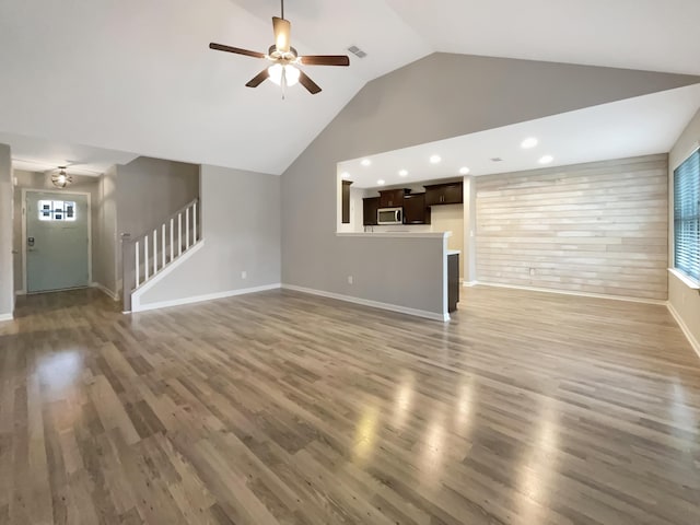 unfurnished living room with ceiling fan, dark hardwood / wood-style floors, and lofted ceiling