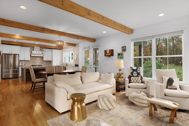 living room with light hardwood / wood-style flooring and beamed ceiling