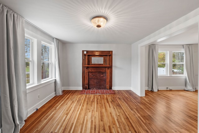 unfurnished living room featuring a healthy amount of sunlight and light hardwood / wood-style flooring