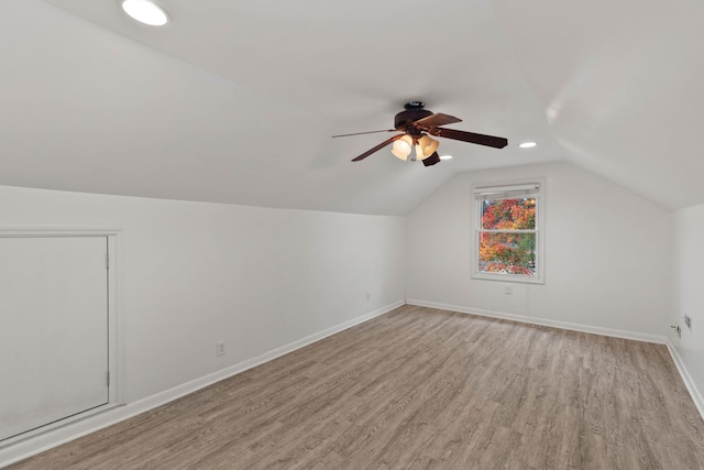 additional living space featuring light wood-type flooring, lofted ceiling, and ceiling fan